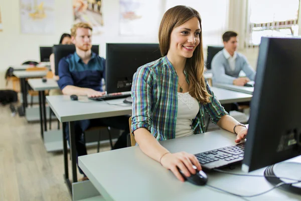 Junges schönes Mädchen, das an einem Computer arbeitet — Stockfoto