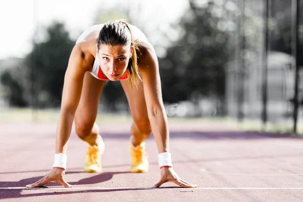 Feminino sprinter se preparando para a corrida — Fotografia de Stock