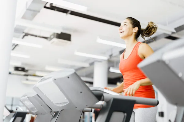 Hermosa mujer corriendo en una cinta de correr — Foto de Stock