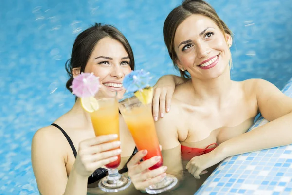 Mujeres tomando un cóctel en la piscina — Foto de Stock