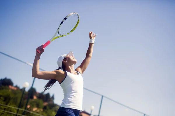 Beautiful female tennis player serving — Stock Photo, Image