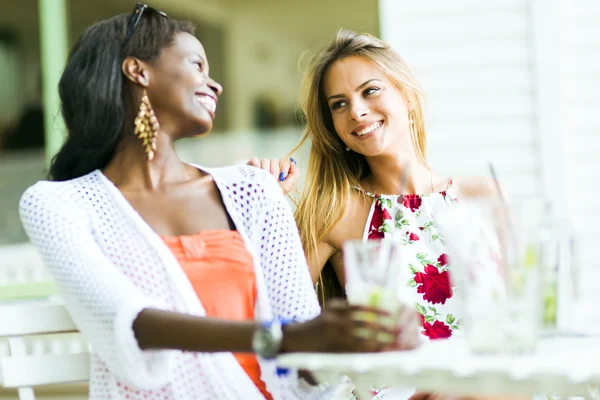 Happy friends sitting talking at a table — Stock Photo, Image