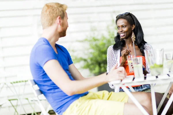 Amigos felices sentados hablando en una mesa —  Fotos de Stock