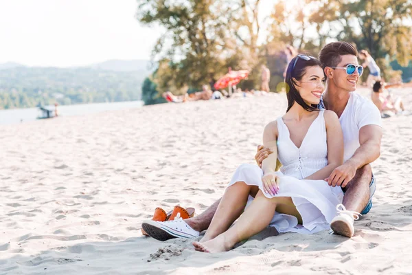 Casal romântico sentado em uma praia — Fotografia de Stock