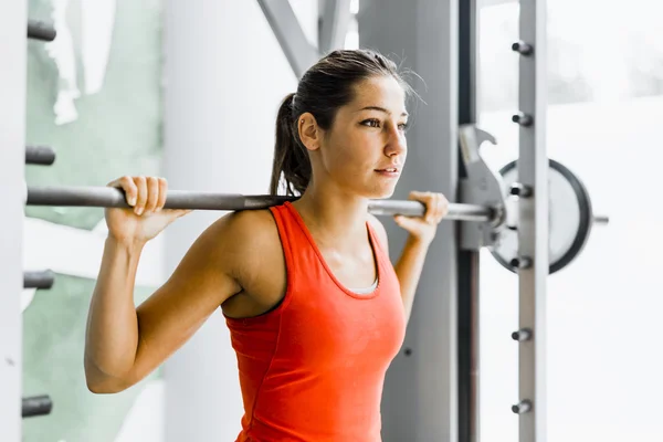 Mujer levantando pesas en un gimnasio —  Fotos de Stock