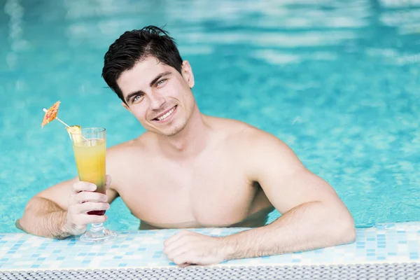 Handsome man drinking a cocktail in the water