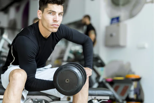 Hombre joven entrenando en un gimnasio — Foto de Stock