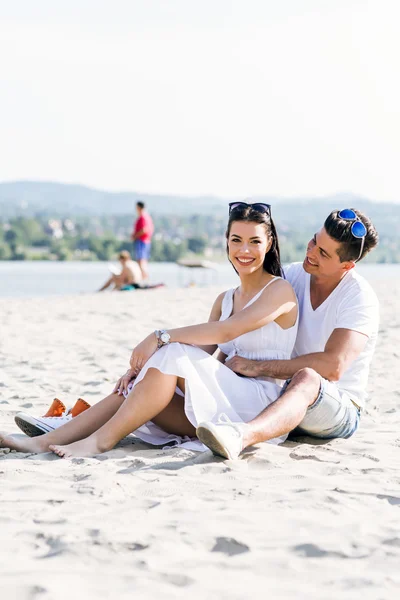 Romantiska paret sitter vid en strand — Stockfoto