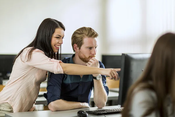 Mulher jovem ajudando colega de classe entender — Fotografia de Stock