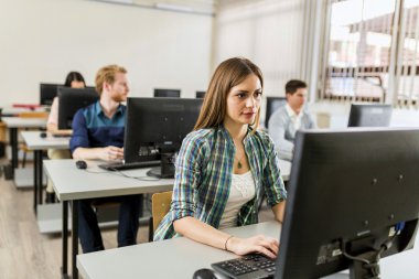 Bir bilgisayarda çalışan genç güzel kız