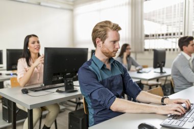 Genç yakışıklı öğrenci bilgisayar kullanarak