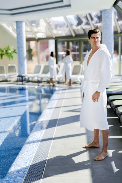 Mann steht im Bademantel neben einem Pool — Stockfoto