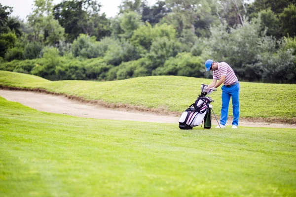 Golfspelare att välja ut lämpliga club — Stockfoto