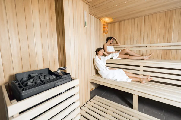 Sauna heater and girls relaxing — Stock Photo, Image