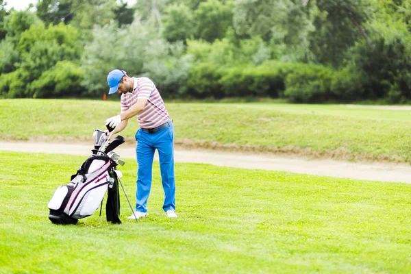 Golfspelare att välja ut lämpliga club — Stockfoto