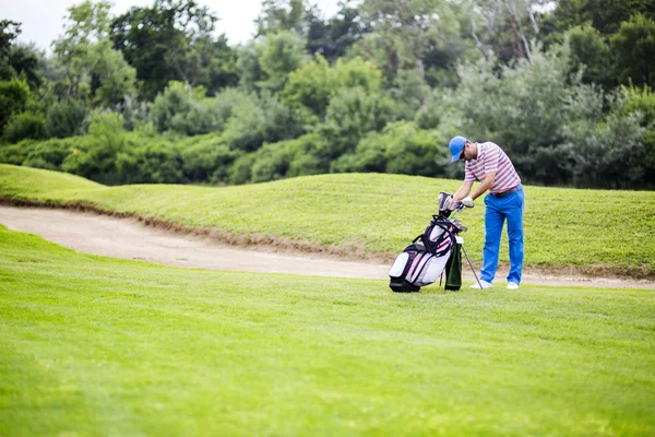 Golfspelare att välja ut lämpliga club — Stockfoto