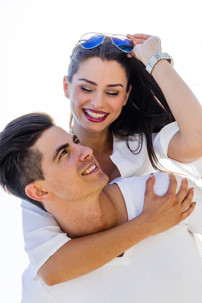 Bonito homem carregando sua namorada piggyback — Fotografia de Stock