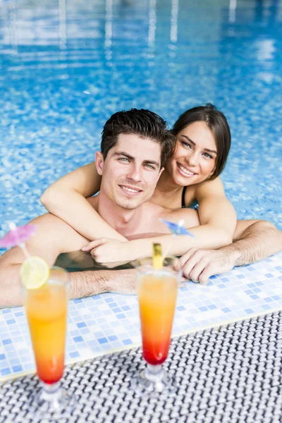 Couple drinking a cocktails by the swimming pool — Stock Photo, Image