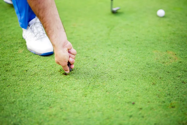 Golf játékos javítása tőzegkocka — Stock Fotó