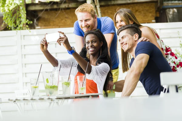 Um grupo de amigos sorrindo tirando selfies — Fotografia de Stock