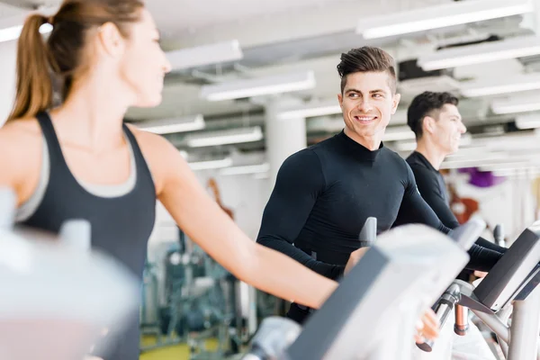 Hombre y mujer usando un paso en un gimnasio — Foto de Stock