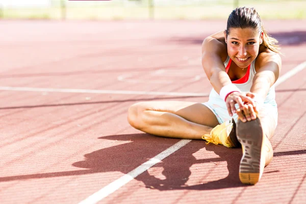 Athletic woman stretching in summer — Stock Photo, Image