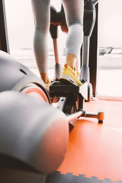 Legs of a female using elliptical trainer — Stock Photo, Image