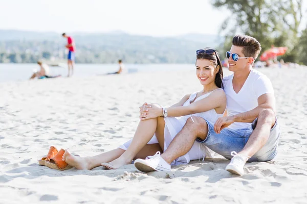 Romantisch paar zittend op een strand — Stockfoto
