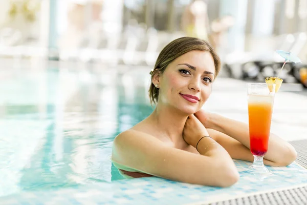 Schöne Frau in einem Pool mit einem Cocktail — Stockfoto