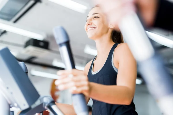 Beautiful lady using the elliptical trainer — Stock Photo, Image