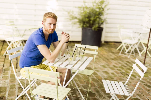 Thoughtful ginger male waiting at a table — Stock Photo, Image