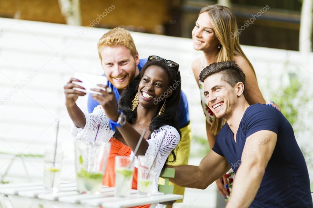 A group of friends smiling taking selfies