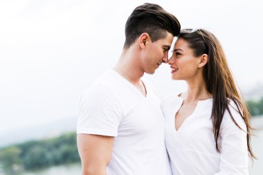 Young couple rubbing noses as a sign of love clipart