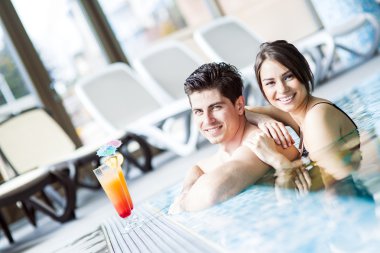 Yüzme havuzun kenarında bir kokteyl içme Çift