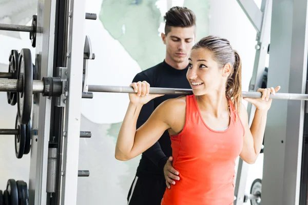Tränare att ge instruktioner till en kvinna i ett gym — Stockfoto