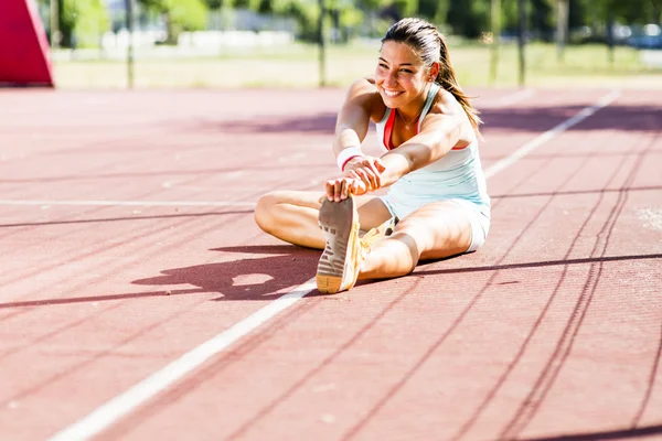 Schöne athletische Frau dehnt sich im Sommer — Stockfoto