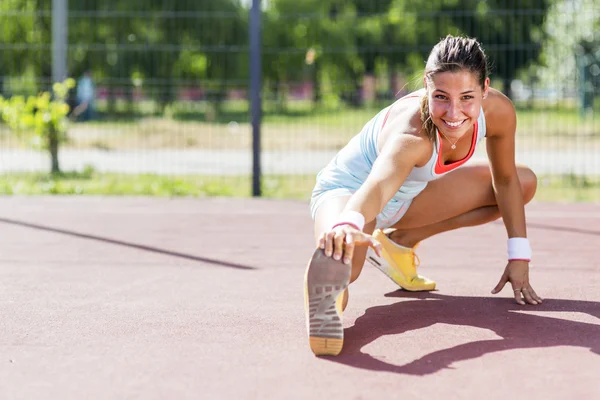 Schöne athletische Frau dehnt sich im Sommer — Stockfoto