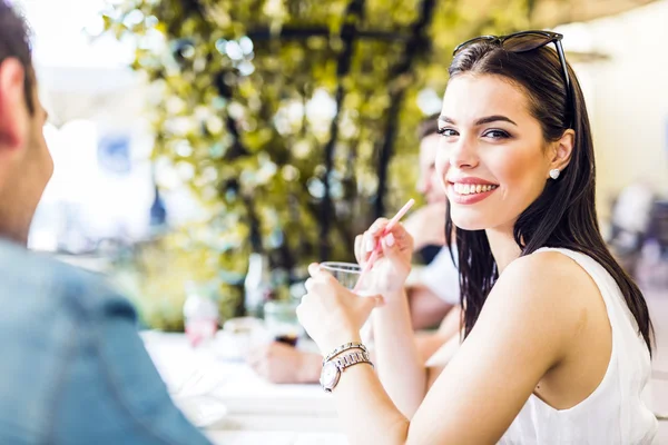 Beautiful woman sitting at a table — Stock Photo, Image
