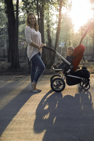 Mutter läuft Kind im Kinderwagen — Stockfoto