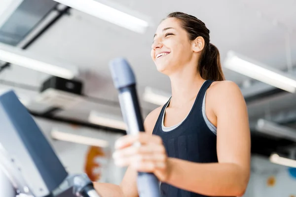 Schöne Dame mit dem Crosstrainer — Stockfoto