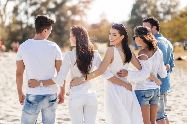 Grupp av människor höll händerna på stranden — Stockfoto