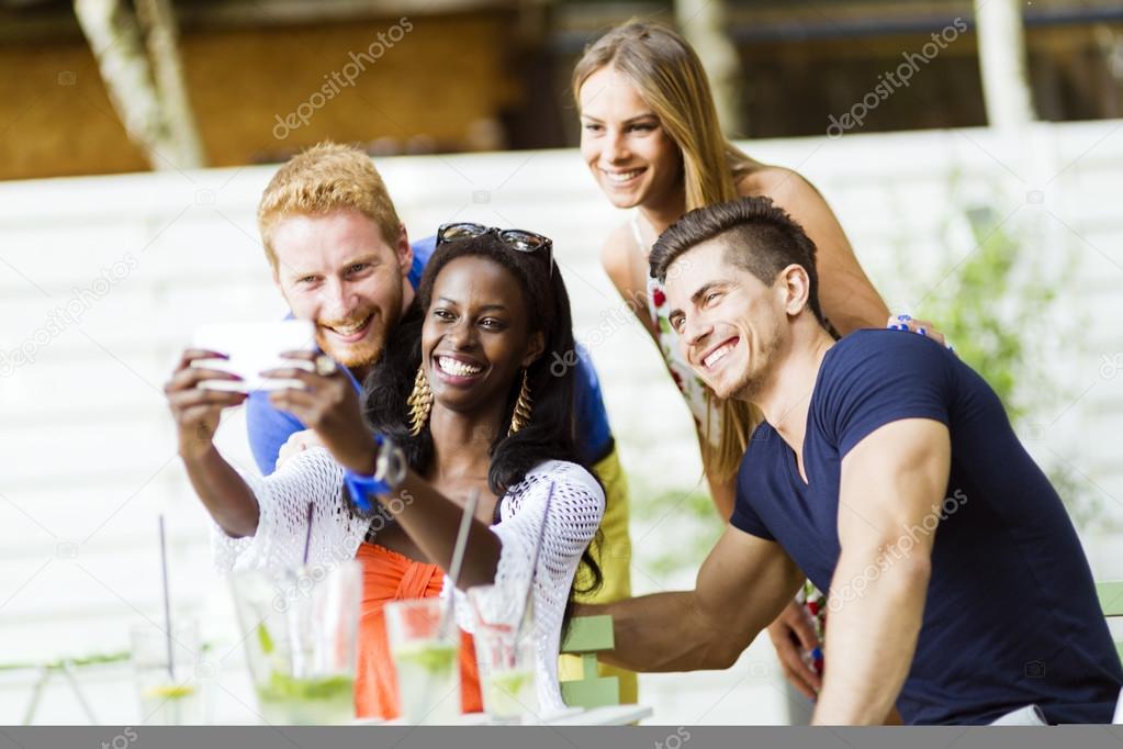 A group of friends taking selfies