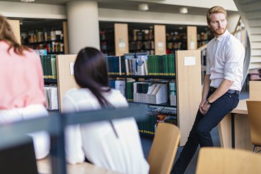 Bir grup insan bir kitaplıkta kendilerini eğitmek