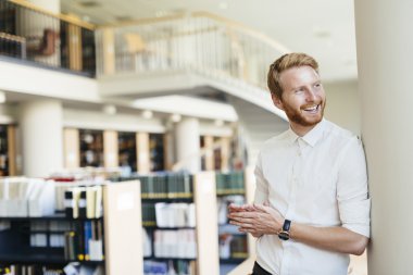 Yakışıklı öğrenci Kitaplığı'nda gülümseyen