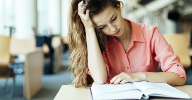 Kütüphanede okuyan kız öğrenci