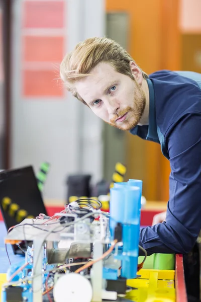 Engenheiro elétrico programando um robô — Fotografia de Stock