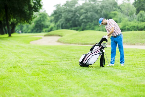 Golfspelare att välja ut lämpliga club — Stockfoto