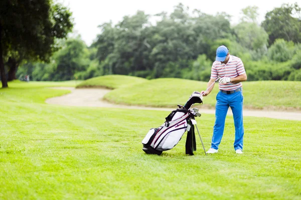 Golfspelare att välja ut lämpliga club — Stockfoto