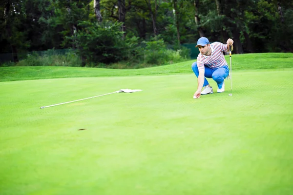Jogador de golfe marcando bola no putting green — Fotografia de Stock