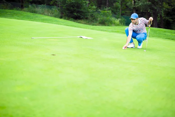 Golfspeler markering bal op de putting green — Stockfoto